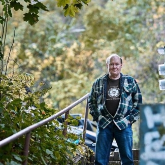 The author in nature, wearing a flannel shirt and jeans