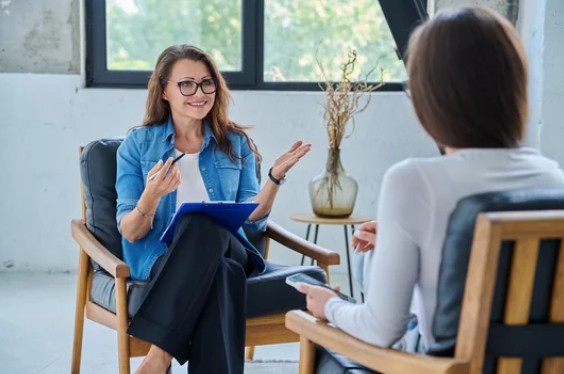 Two_women_sitting_speaking
