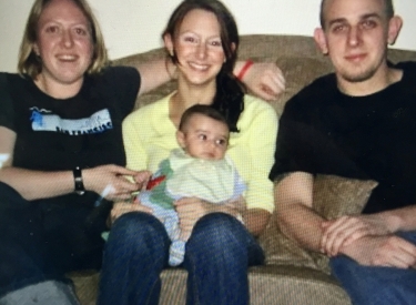 A family photo of the author and her siblings: A teenaged girl holding a baby, and a young man next to her, all seated on a couch