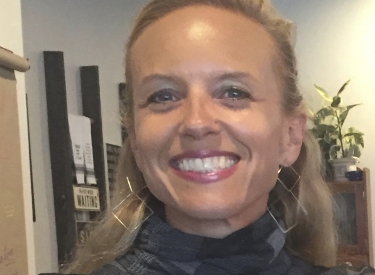 Stephanie Palatt, a white woman with blonde hair, wearing a plaid grey turtleneck