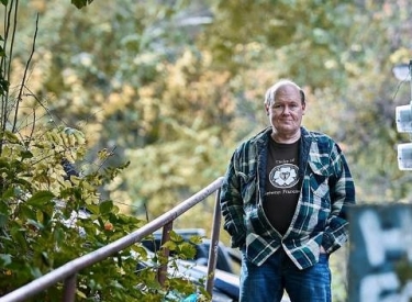 The author in nature, wearing a flannel shirt and jeans