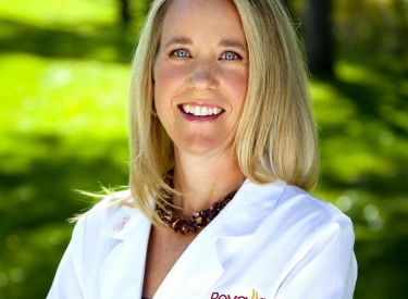 Headshot of Dr. Lisa Hunsicker, a blonde woman in a white lab coat standing outside