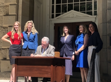 Key advocates, including Shatterproof's Courtney Hunter, watch Governor Sisolak sign legislation on the steps of the capitol building
