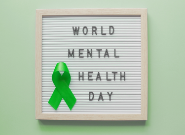 A green ribbon next to a sign that says "world mental health day"