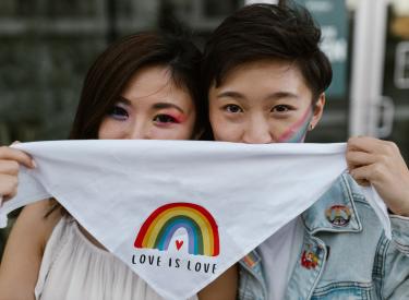 Two people holding rainbow handkerchief