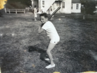 The author, posing with a baseball bat as a child